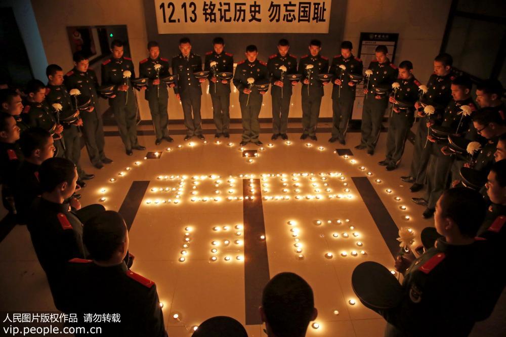 全國各地悼念南京大屠殺遇難同胞：江蘇公安邊防總隊常州邊防檢查站的戰士點燃蠟燭並脫帽默哀