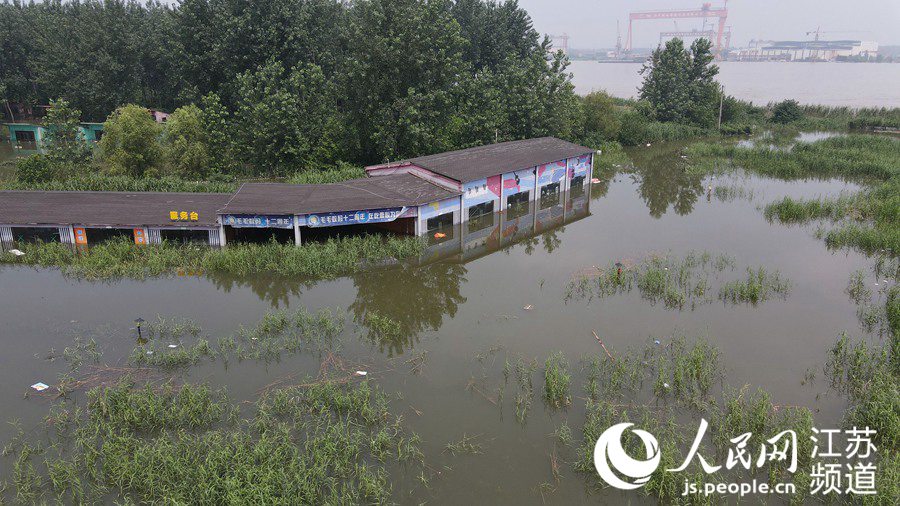 7月20日，在江蘇省鎮江市世業洲，低窪處房屋被洪水淹沒。