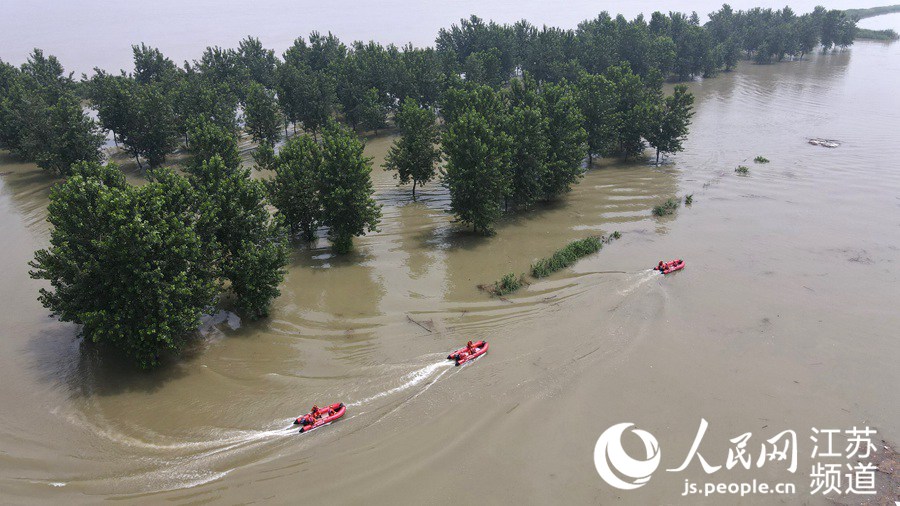 7月20日，在江蘇省鎮江市世業洲，揚州市消防救援支隊的消防員乘坐橡皮艇巡查災情（無人機拍攝）。 