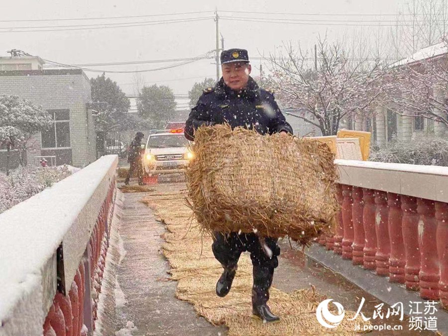 南京市浦口區城管隊員在橋面上鋪設防滑墊。史璐娟攝