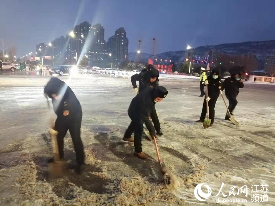 天色已暗，連雲港市的城管隊員們仍在清掃積雪。朱曉潔攝