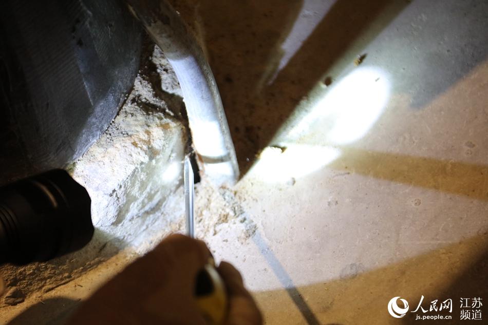 在一根木質柱子底端，工作人員發現了白蟻洞穴。人民網 馬燾燾攝