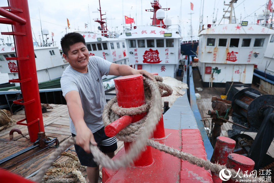 7月22日，渔民在连云港市赣榆区青口中心渔港加固渔船。司伟摄