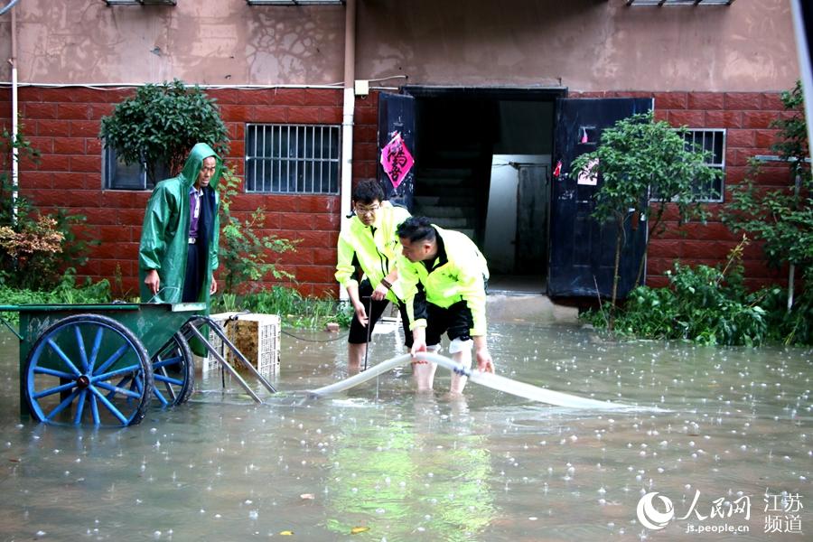 社區工作人員冒雨排水搶險。祖方攝