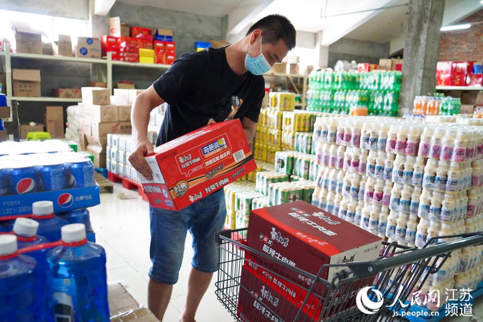 下午一點，一家超市的老板將方便面、飲用水等物資搬上貨車，即將捐送到疫情防控一線。