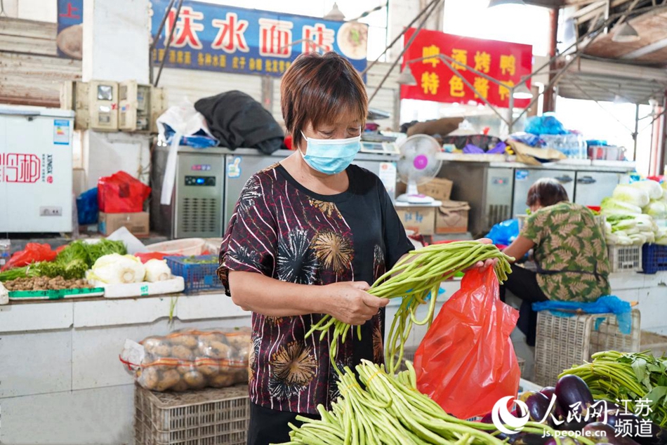 早上八點，居民孫志娟到石港農貿市場買菜，她最近總是選擇一次採購兩天的量，盡量減少外出。