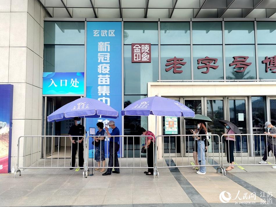 在南京市玄武区新庄国展中心集中接种点，市民正在有序排队等待接种。人民网 马晓波摄