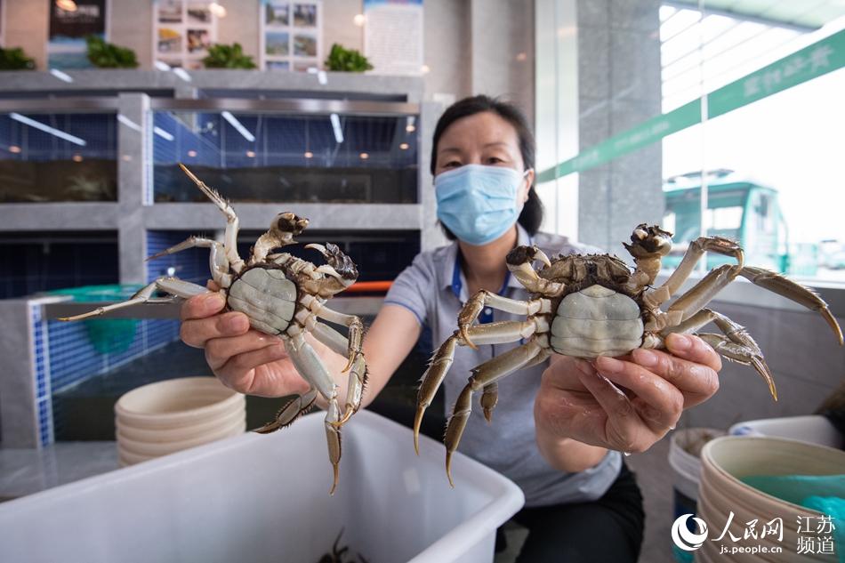 市場內商戶展示手中的螃蟹。劉列攝