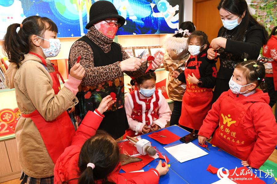 雨花台區少兒圖書館內，江蘇省級剪紙傳承人給小朋友們上剪紙課。江鑫攝