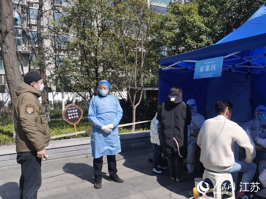 2月24日上午，在姑蘇區三香公園內，王新（中）在核酸檢測採樣點維持秩序。人民網記者 王繼亮攝