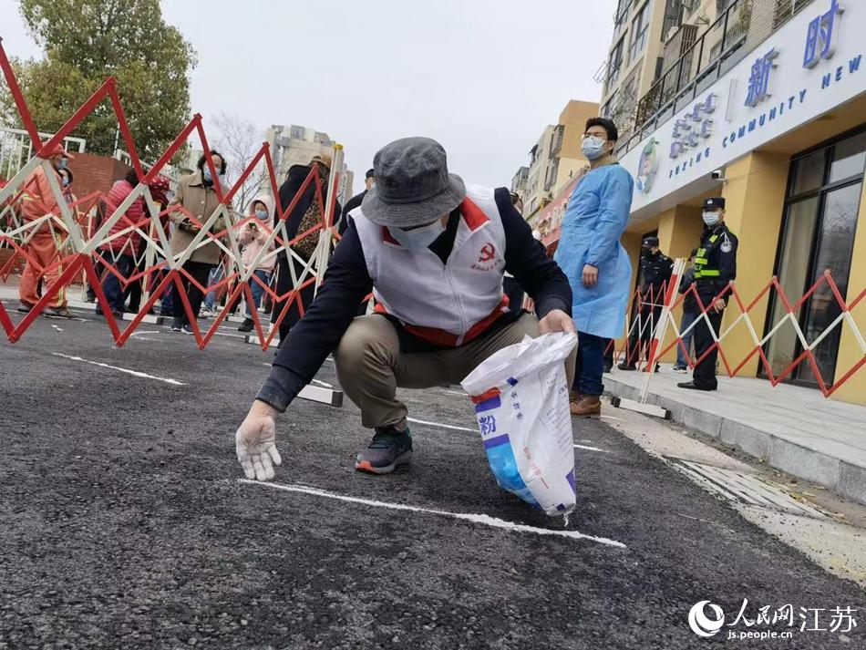 工作人員在核酸檢測點位前設置一米線。高麗攝