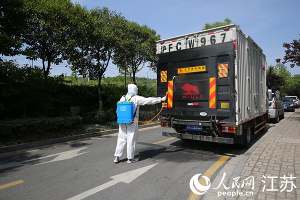 杨连明的车到达目的地，企业工作人员进行消毒。卢雨文摄