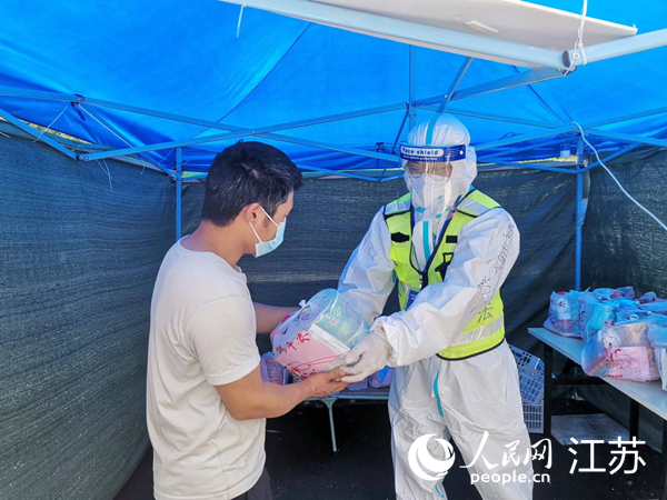 查驗點防疫人員向從上海來寧的貨車司機發放免費物資。人民網 張瀚天攝