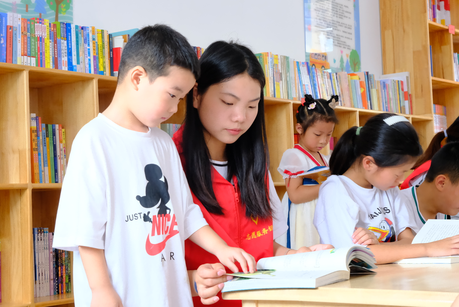 图为志愿者为孩子读书。灌南县委宣传部供图