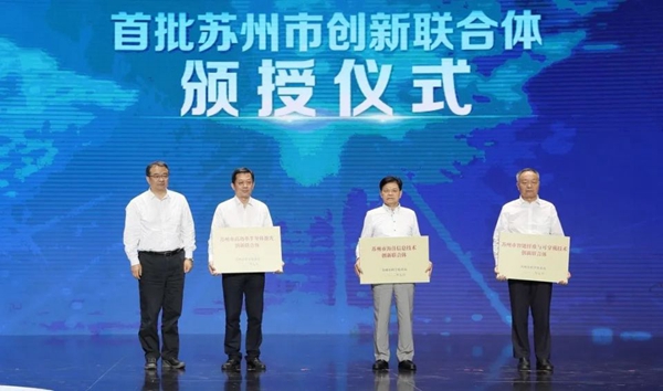 苏州首批三个创新联合体授牌成立，亨通集团党委书记、董事局主席崔根良（右二）上台领受牌匾。
