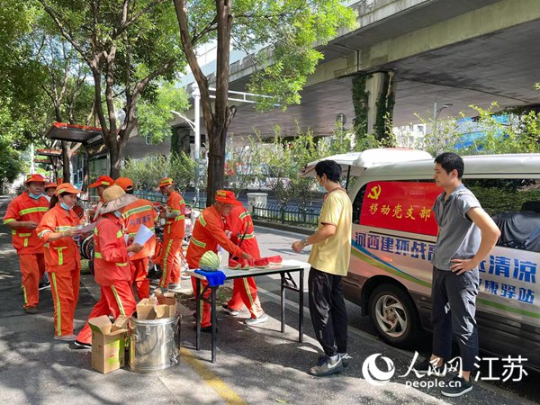 南京市建鄴區通過移動“安康驛站”為環衛工送來冰棍、西瓜等防暑降溫物資。人民網 李子佩攝