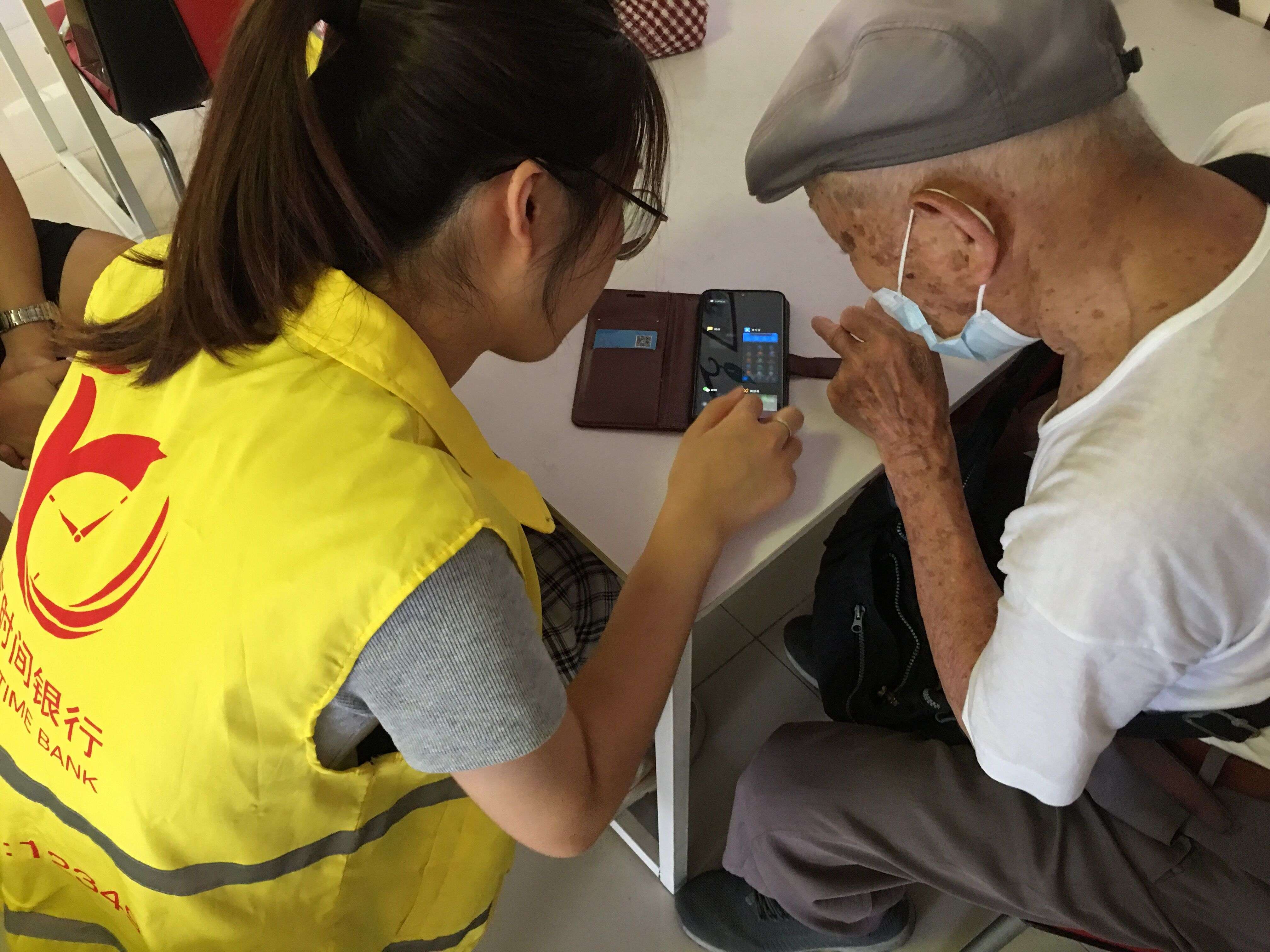 “时间银行”志愿者教老人使用手机。王敏摄