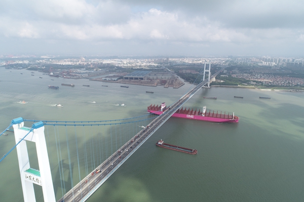 图为海巡艇护航长江干线新造最大集装箱船经过桥区，出江试航。泰州海事局供图