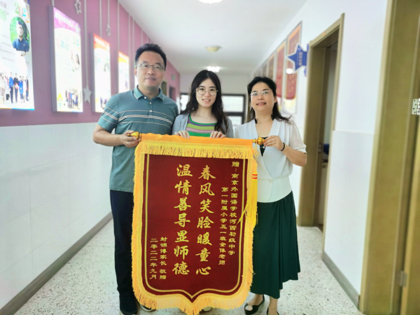  孩子轉學后成績有了較大進步，今年9月，姜坤琴向老師們送上錦旗。建宣攝