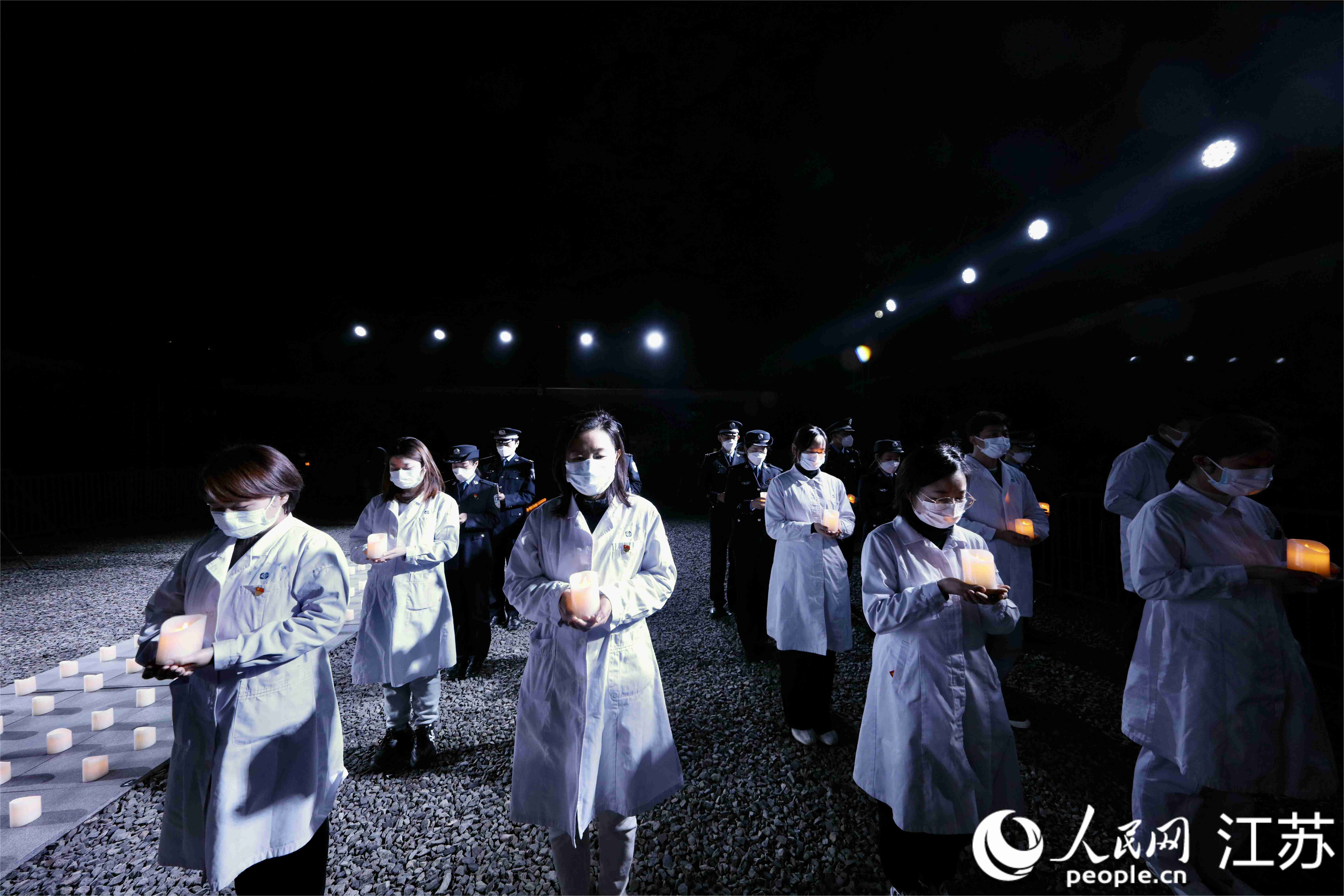 社會各界人士手捧白燭。 人民網 馬燾燾 攝