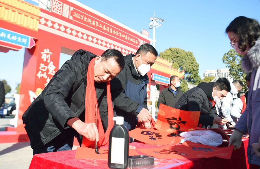 16名书法家协会成员挥毫泼墨，用红红火火的对联向广大市民送上节日祝福。陈义宝摄