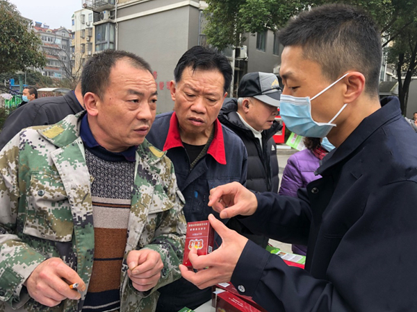 普法人员正在与消费者交流真假烟鉴别小知识。南京烟草供图