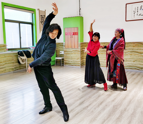 田海燕夫妻正在指导王建群（中）练习舞蹈。人民网记者 王继亮摄
