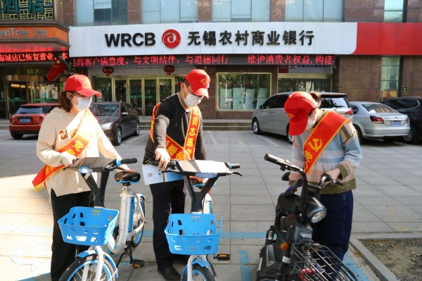 党员志愿者将共享单车摆放整齐。靖江烟草供图