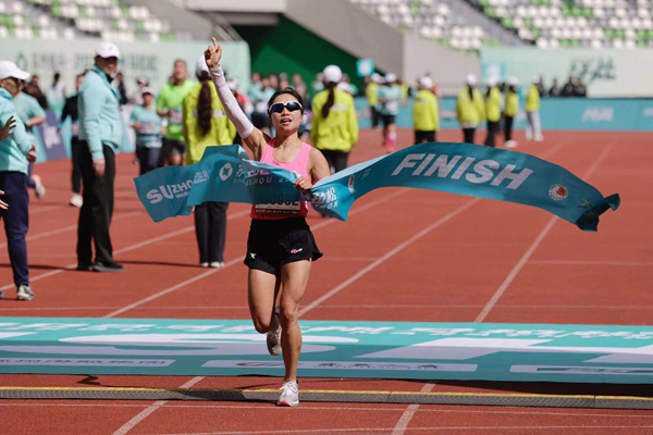 女子马拉松冠军杨花冲过位于苏州奥林匹克体育中心体育场的终点线。赛事组委会供图
