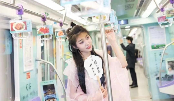 身穿漢服的“小姐姐”在句容文旅地鐵專列裡打卡拍照。句容市文體廣電和旅游局供圖