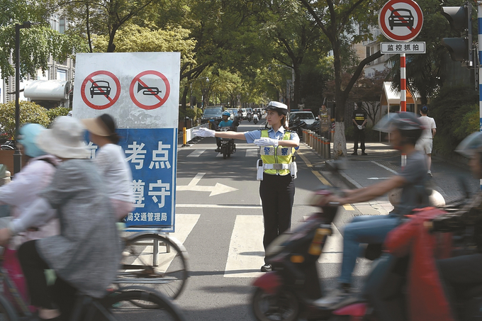昨日是高考第二天。图为南京九中考点，交警对考场周边路段进行交通管制。本报记者 吴俊 摄