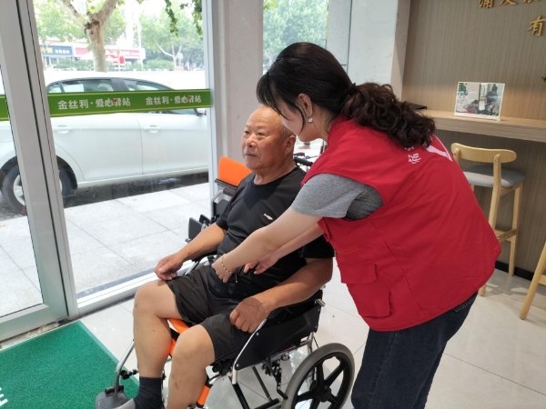 驛站志願者為老人調試輪椅。宿遷煙草供圖