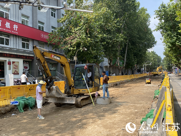 青年路上，雨水支管安装和路面平整工作同步进行。人民网 杨维琼摄