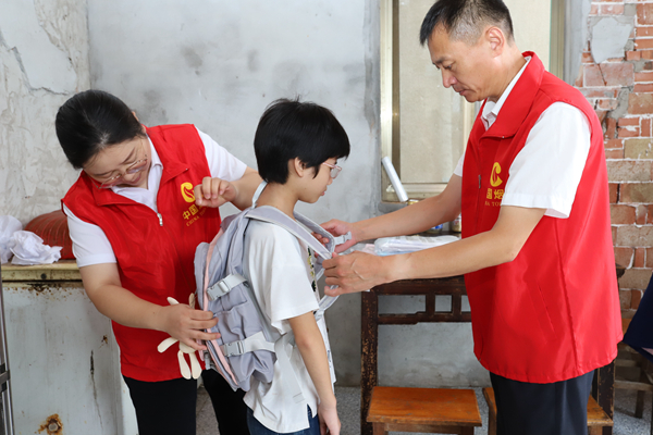 如東“金葉”志願者為兒童送上新書包。如東煙草供圖
