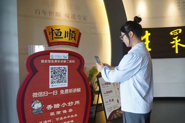 在鎮江醋文化博物館，游客掃描二維碼收看5G人工智能講解。江蘇移動供圖