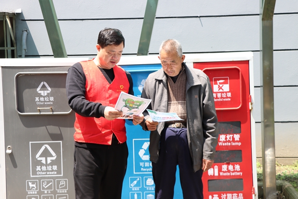 志愿者向居民宣传垃圾分类知识。泰州烟草供图