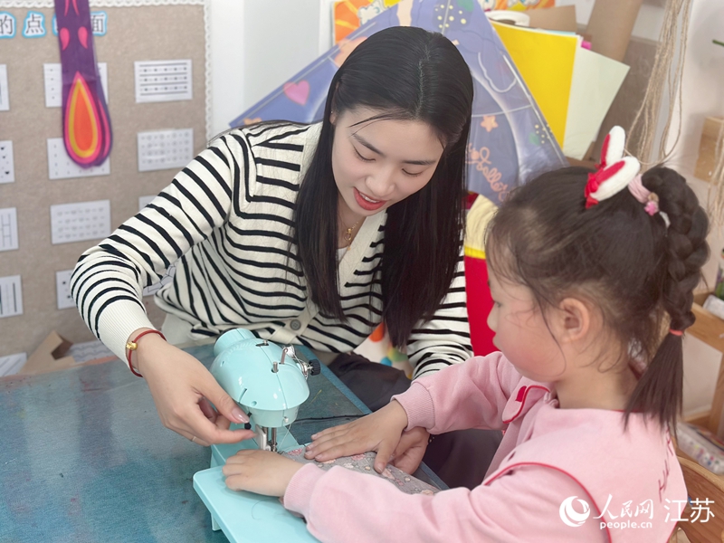 朱硕硕带着孩子们缝制衣服。人民网记者 马晓波