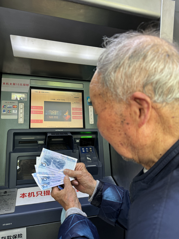 老人在ATM机上支取零钱。工行南京分行供图