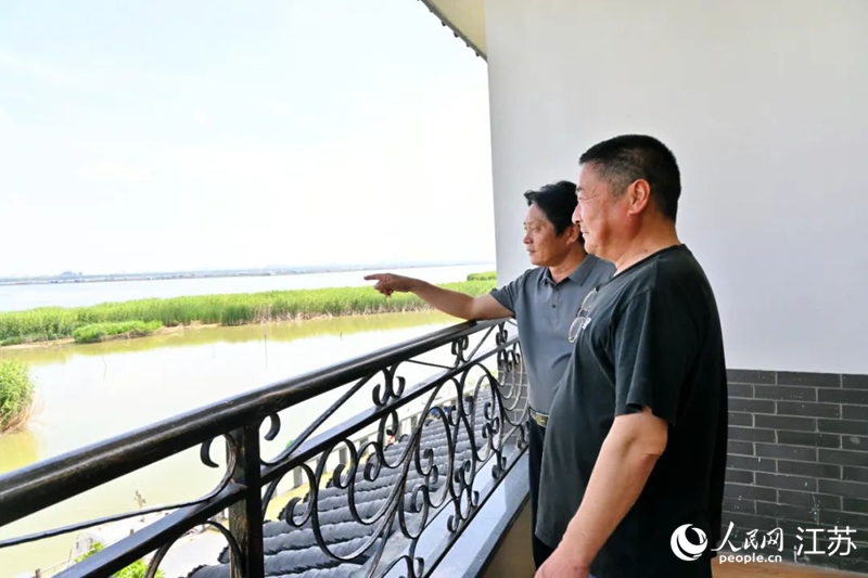 王卫林（右）和李金福（左）在阳澄湖边，眺望远处的养殖水域。人民网 鞠峰摄