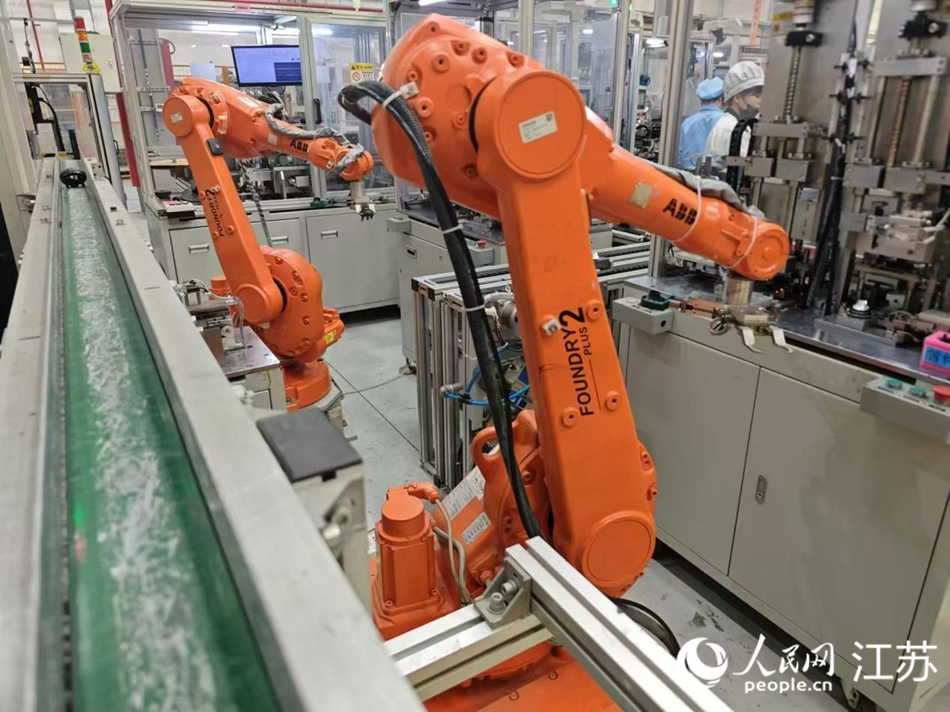  In the workshop of Pursuit Technology (Suzhou) Co., Ltd., the mechanical arm sends materials to the next link of the assembly line. Photographed by Xu Chenxi on People's Daily Online