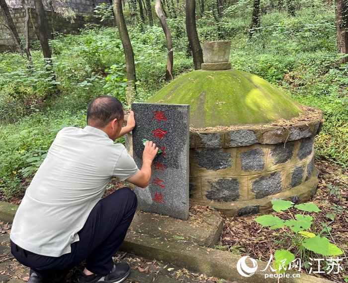 贺龙广在清扫烈士墓。人民网 王丹丹摄