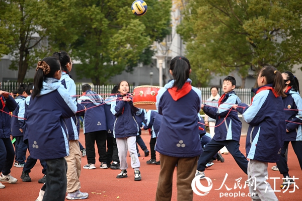 無錫市新吳區江溪小學學生課間在操場上一起玩同心鼓。 人民網 鞠峰攝