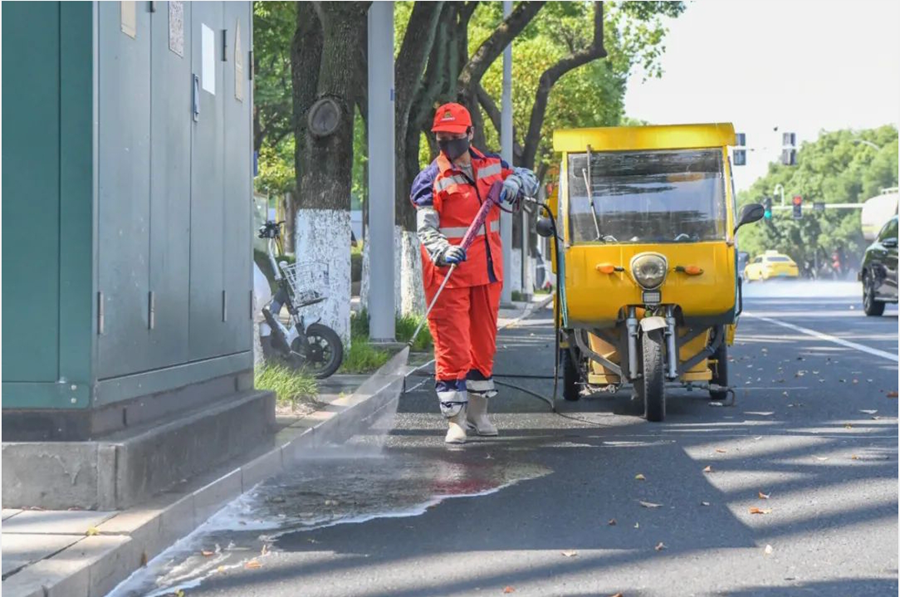环卫工人驾驶清洁车清扫路面。吴茜摄