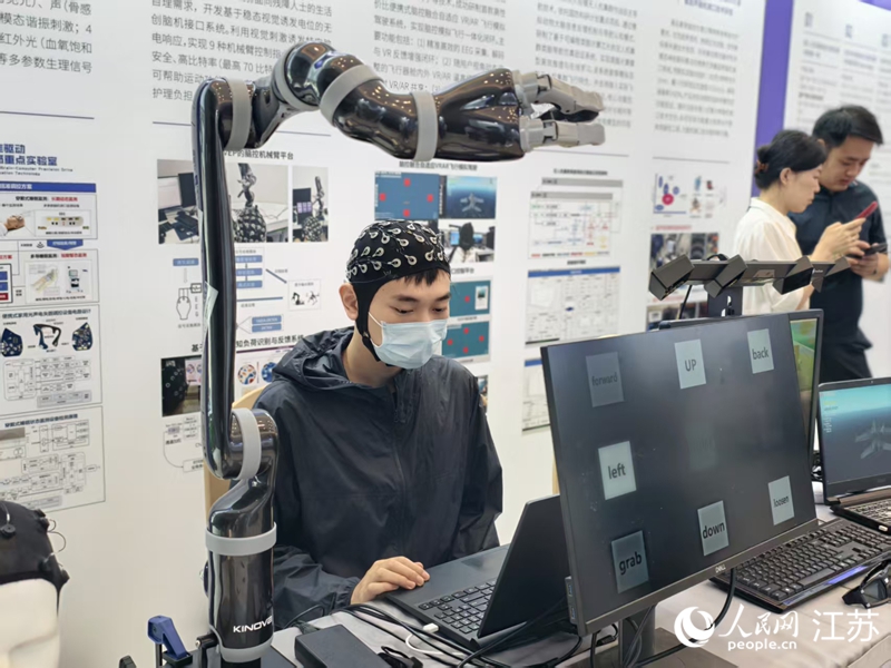 南京航空航天大学展示非侵入式脑机接口设备，人可通过意念控制机械臂。人民网记者 马晓波摄