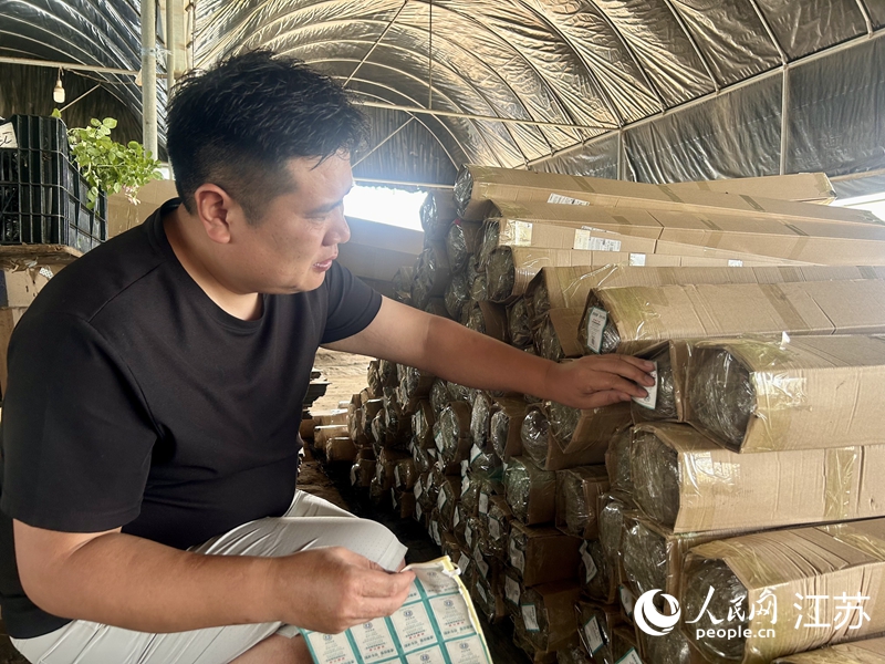 江苏地种花月季玫瑰园内，工作人员在快递盒上粘贴“诚信标签”。人民网 王丹丹摄
