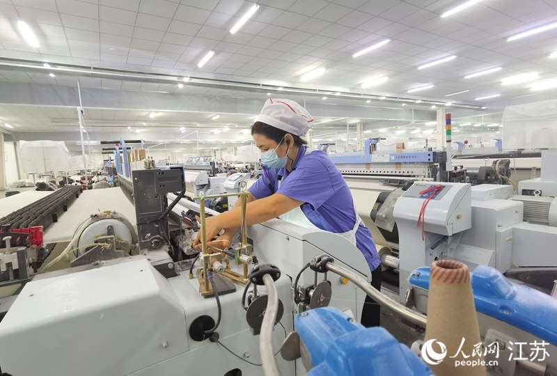 正在操作紡機的扎依旦。人民網記者 王繼亮攝