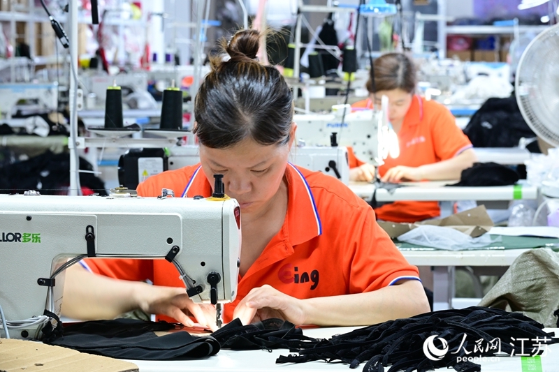 灌云伊影服饰有限公司车间内，女工正在赶制服饰。人民网记者 张瀚天摄
