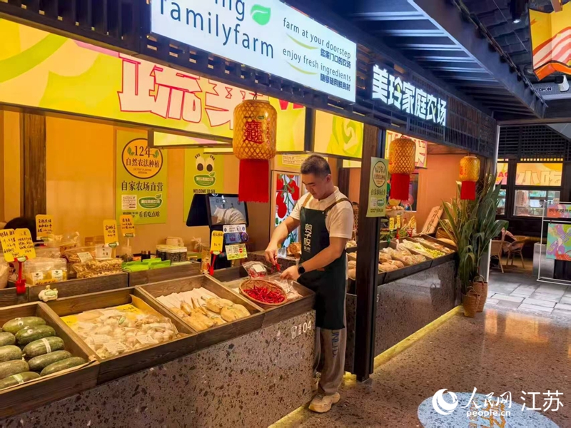 孫放在剪子股菜市裡的攤位,經營自家農場的蔬果。人民網 李欣陽攝