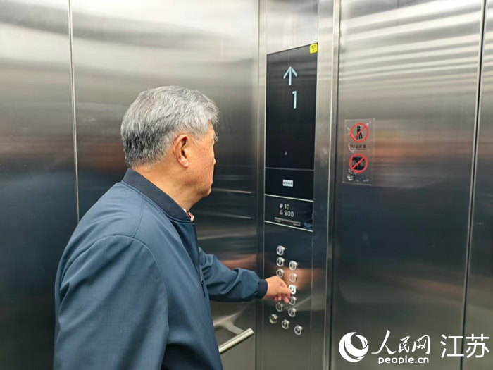 江南名府小區居民王樹立在使用電梯。人民網記者 馬曉波