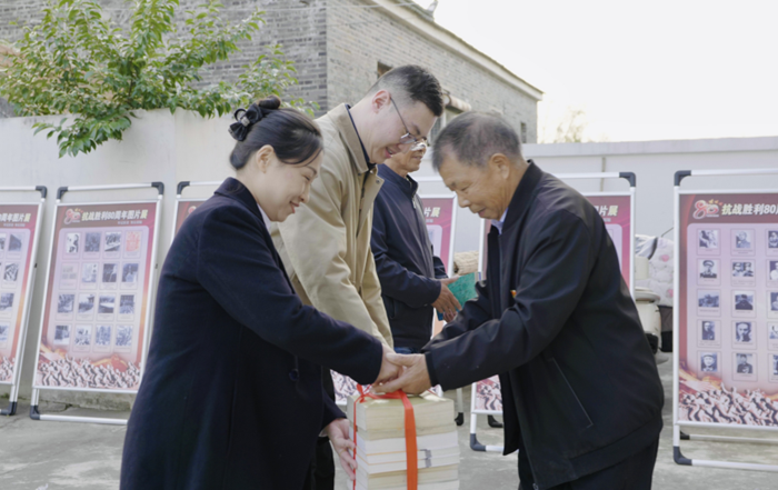 盐城烟草城区部工作人员为乐绍琪赠送书籍。盐城烟草供图